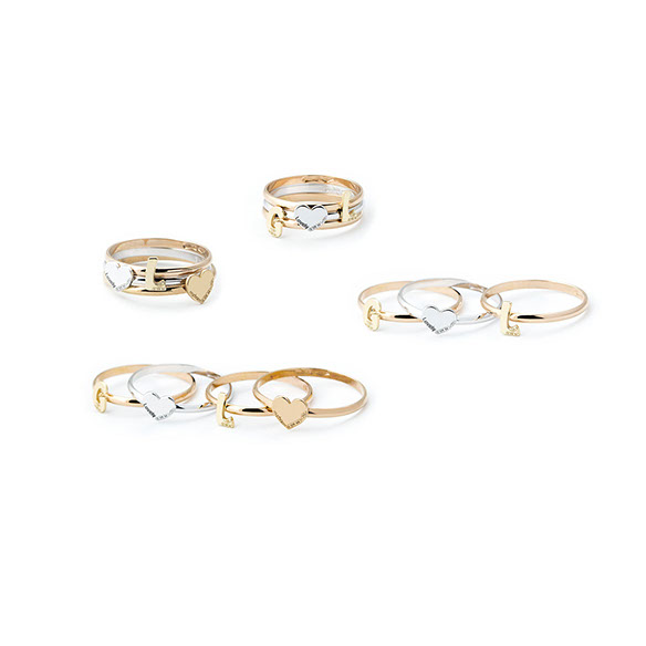 Anelli della Mycharm sullo sfondo bianco, oro bianco, giallo e rosa, anelli componibili con i cuori e le lettere. Scatto per il catalogo.
